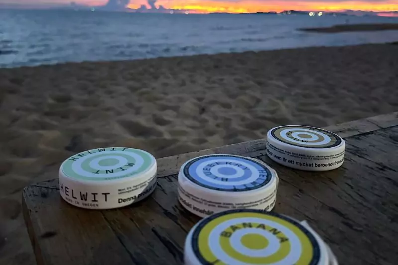 Helwit tobacco-free nicotine pouches on a beach table in Thailand, ideal for tropical use.